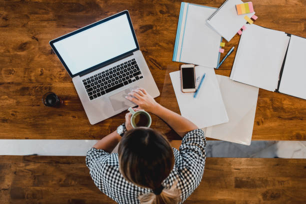 istock High angle view of a Chinese woman working at home and using a computer 995962806