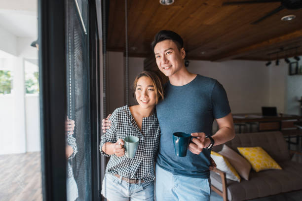 istock Chinese couple standing by the window with coffee 995962968