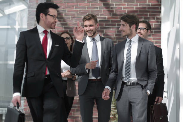 istock businessman and his team walking down the office corridor 995971480