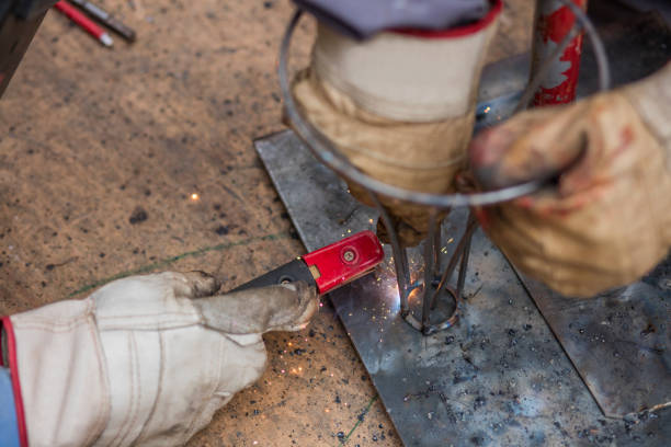 istock Welders in metal workshop welding wires. 995978872