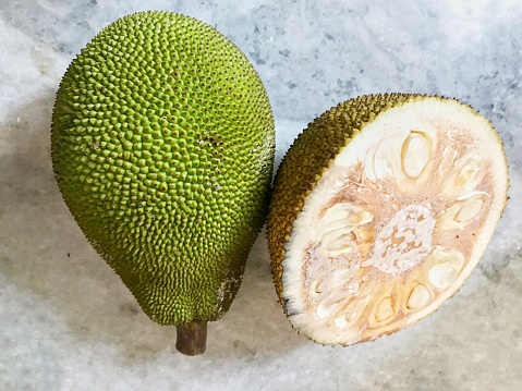 A jackfruit and half a piece of a jackfruit