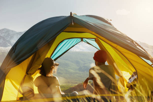 istock Couple rest in tent against mountains sunset 995987780