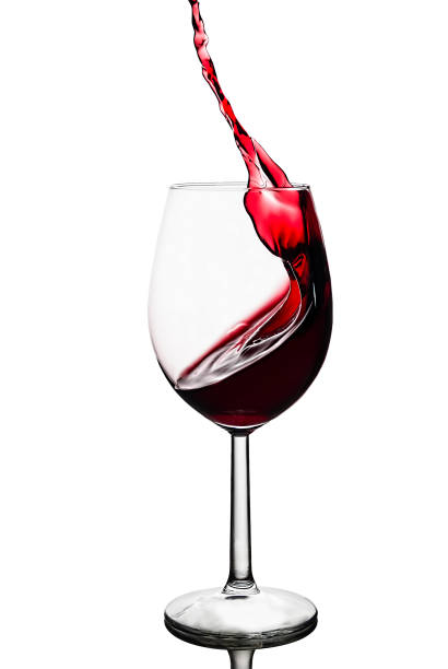 splash of red wine in a wineglass isolated on a white background stock photo