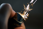 Lighters with flame sparking on dark background.