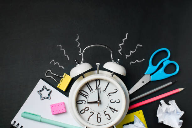 istock Alarm with colorful supplies on black background. 995995784