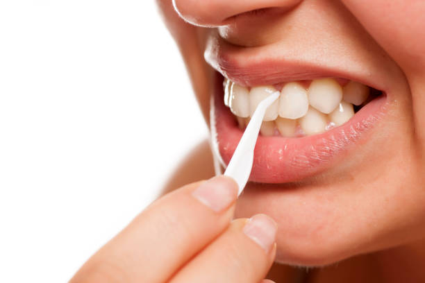 istock young woman cleans her teeth with a plastic toothpick 996001546