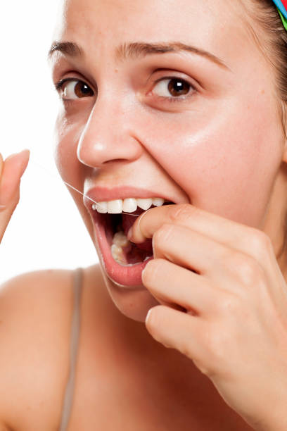 istock young woman cleans her teeth with a dental floss 996001552
