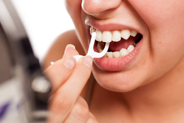 若い女性、デンタルフロスで歯をきれいに - floss toothpick ストックフォトと画像