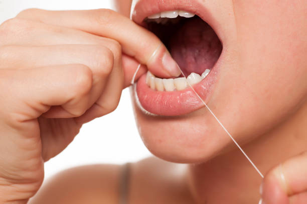 istock young woman cleans her teeth with a dental floss 996001568