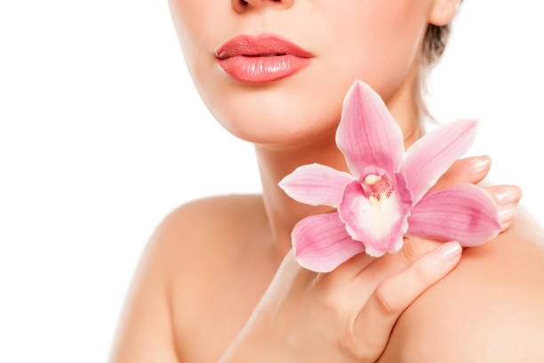 istock a pretty young woman with orchid on her shoulder on a white background 996006070