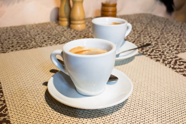 istock Still-life composition, coffee cups, white serving plates, small metal spoons 996014912