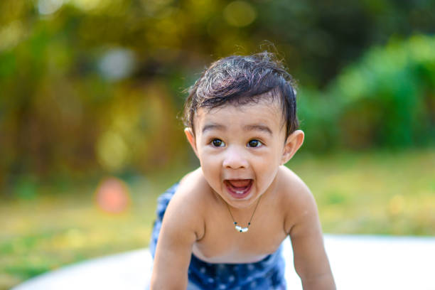 Cute indian baby boy playing at garden stock photo