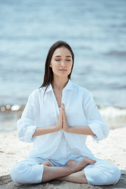 istock young asian woman in anjali mudra (salutation seal) pose on beach 996023048