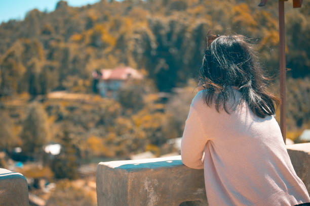 istock Asian woman standing and looking outside 996053668