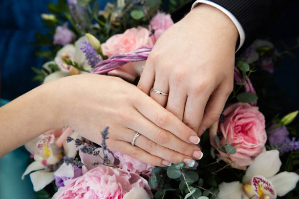istock Bride and groom hands with wedding rings 996054134