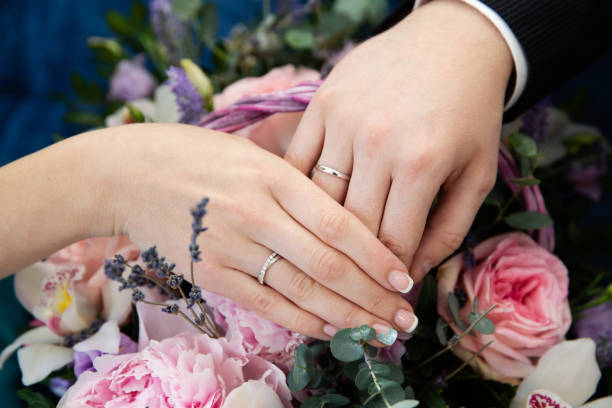 istock Bride and groom hands with wedding rings 996054438