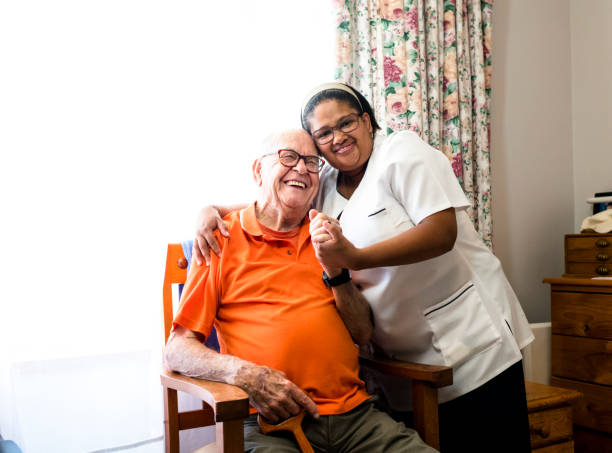 portrait of a smiling senior man and nurse embracing - 96 well imagens e fotografias de stock