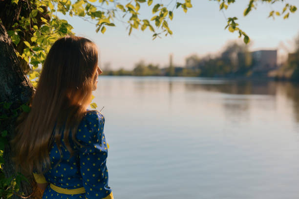 istock Woman with long blond hair looking at the river 996055820