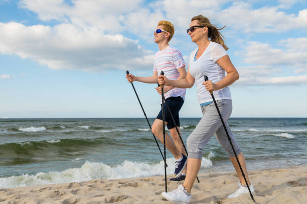 nordic walking-menschen training am strand - power walken stock-fotos und bilder