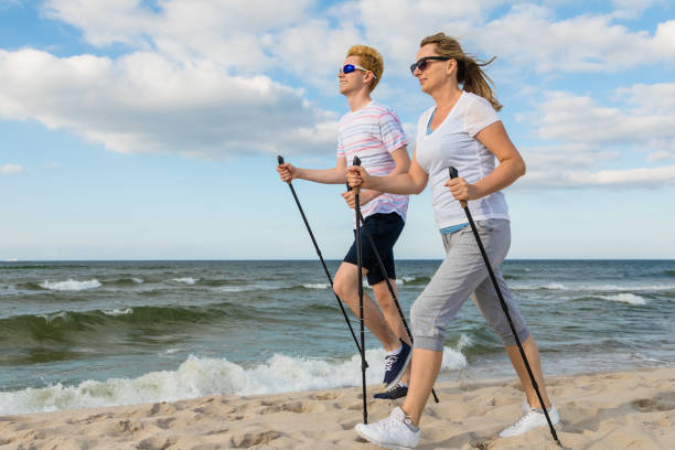 ノルディックウォーキング - ビーチでのトレーニング - nordic walking walking relaxation exercise women ストックフォトと画像