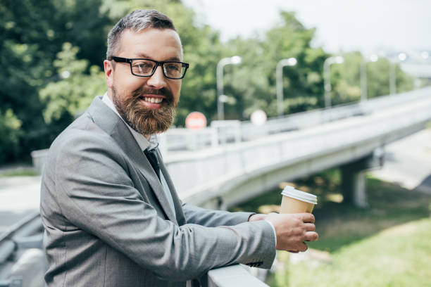 istock handsome businessman holding disposable cup of coffee 996076188