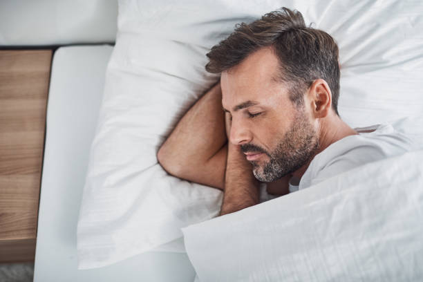 Man sleeping peacefully in bed stock photo