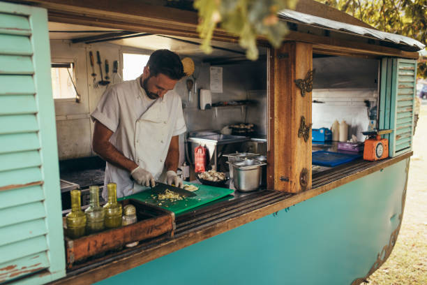 homem cozinhando em um caminhão de comida móvel - empreendedor dentro de seu caminhão - fotografias e filmes do acervo