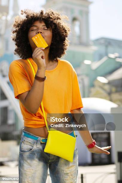 Upbeat Curly Woman Kissing Her Credit Card Stock Photo - Download Image Now - Credit Card, Happiness, Paying