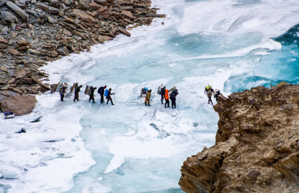 persone che attraversano il fiume zanskar ghiacciato. trekking chadar - kargil foto e immagini stock