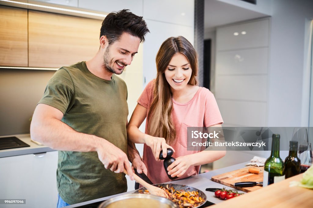 Süße fröhliche Paar zusammen zu kochen und Würze, Essen, lachen und Zeit miteinander zu verbringen, in der Küche - Lizenzfrei Garkochen Stock-Foto