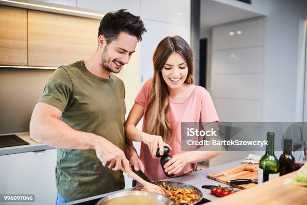Süße Fröhliche Paar Zusammen Zu Kochen Und Würze Essen Lachen Und Zeit Miteinander Zu Verbringen In Der Küche Stockfoto und mehr Bilder von Garkochen