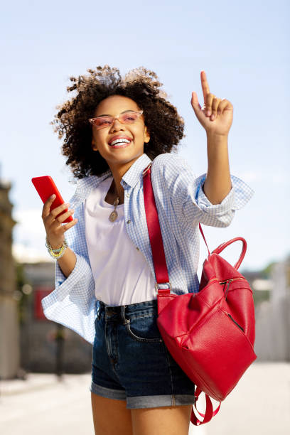 istock Upbeat curly woman checking messages and raising her finger 996097188