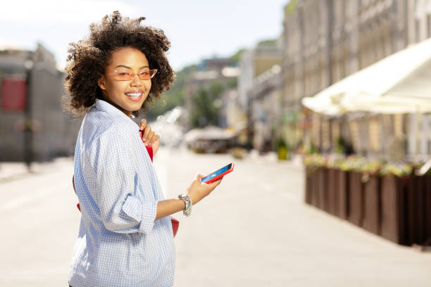 Beautiful woman checking weather forecast while walking