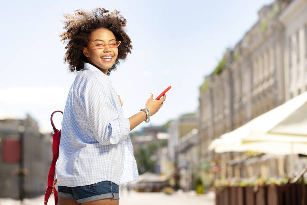 istock Pretty curly woman walking and texting 996097258