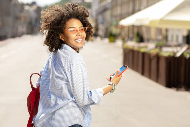 istock Cheerful curly woman checking forecast on her smartphone 996097292