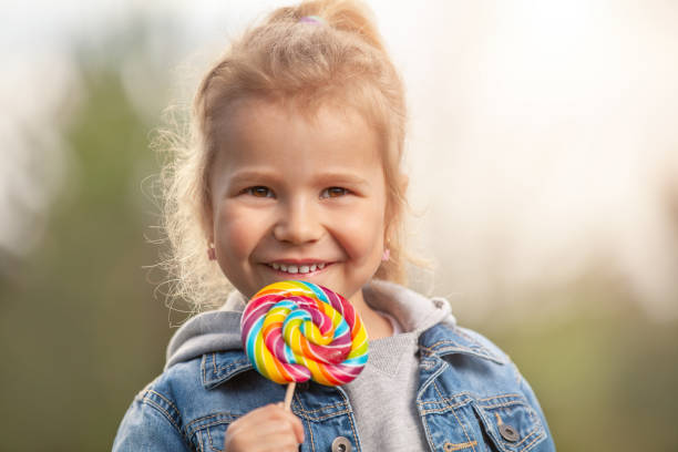 istock Smiling little girl with lollipop 996100436