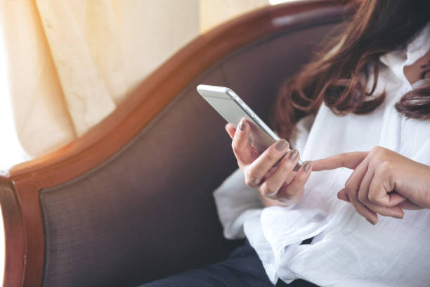 istock Closeup image of a woman holding , using and touching a smart phone 996101016