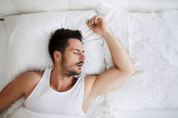 istock Top view of young attractive man sleeping with mouth open 996101106