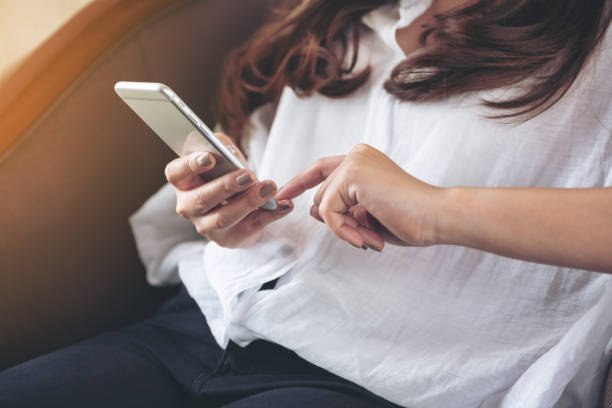 istock Closeup image of a woman holding , using and touching a smart phone 996101122