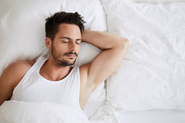 istock Top view of handsome young man sleeping with his hand tucked under head 996105474