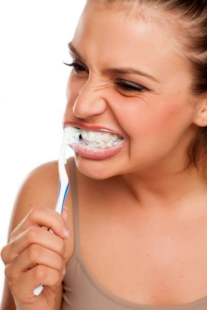 istock young happy woman brushing roughly her teeth on white background 996105894