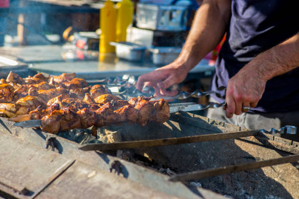 istock man is cooking meat. Barbecue on skewers. 996106074