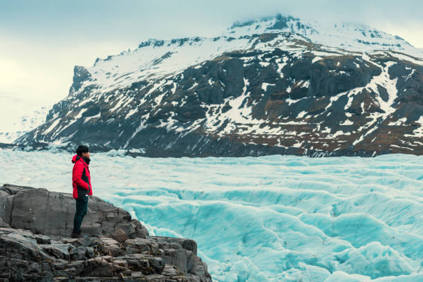 istock Asian young man in red jacket looking the glacier  in iceland 996106304