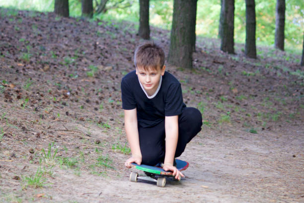 istock A teenager with a skateboard. Sits on a skateboard. 996106422