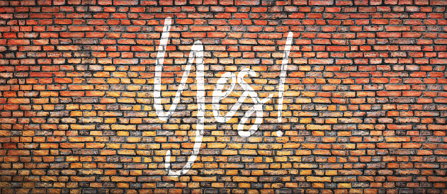 Brick wall with word yes. Concept background
