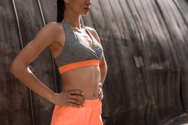 cropped view of athletic woman posing in sports bra cropped view of athletic woman posing in sports bra sports bra stock pictures, royalty-free photos & images