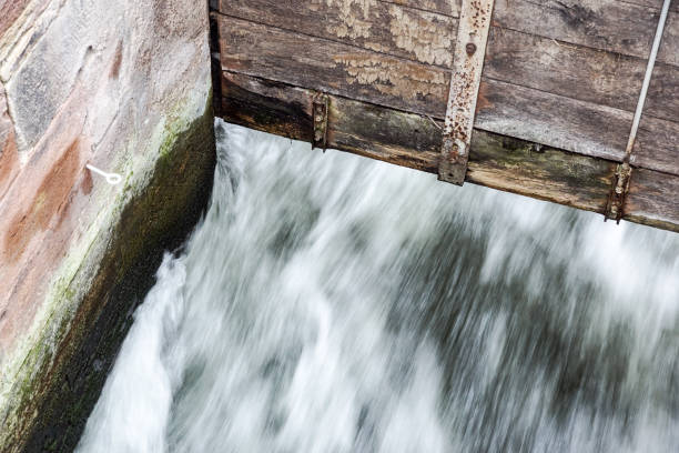 istock detail at small Wooden dam on a mountain river . 996120224