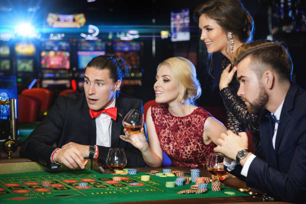 istock Young and rich people playing roulette in the casino 996127718