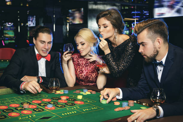 istock Young and rich people playing roulette in the casino 996128416