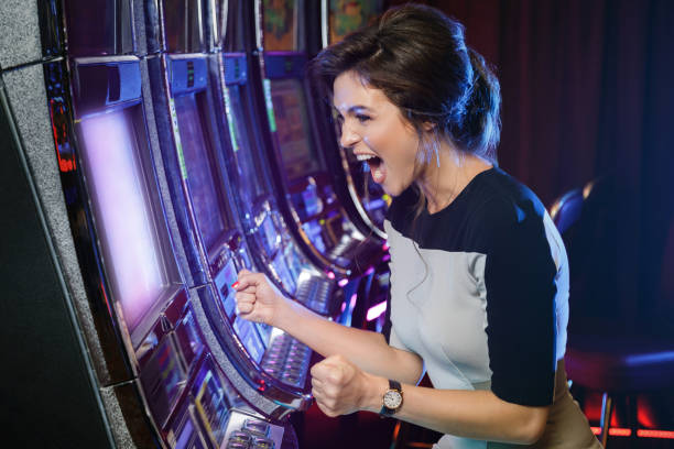 Woman is happy of her win in slot machines Happy woman playing slot machines in the casino jackpot stock pictures, royalty-free photos & images